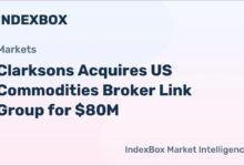 A large container ship loaded with cargo sails across the ocean, symbolizing global shipping.