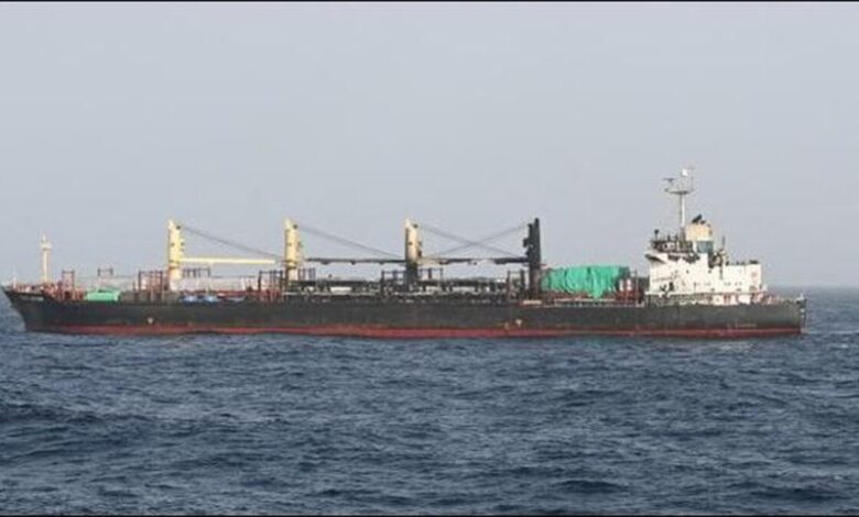 A large bulker engulfed in thick smoke and flames from a fire at sea.