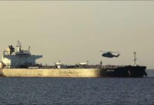 Royal Navy vessel escorts a detained tanker at sea during an enforcement operation.